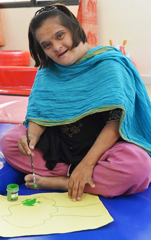 A disabled child paints during her leisure time