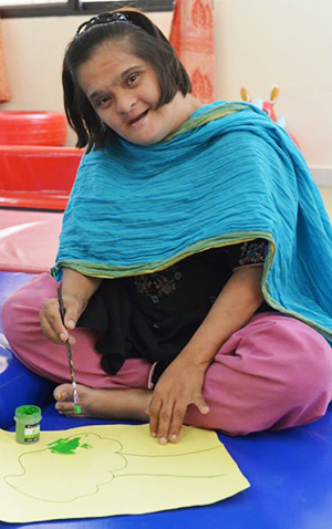A disabled child paints during her leisure time